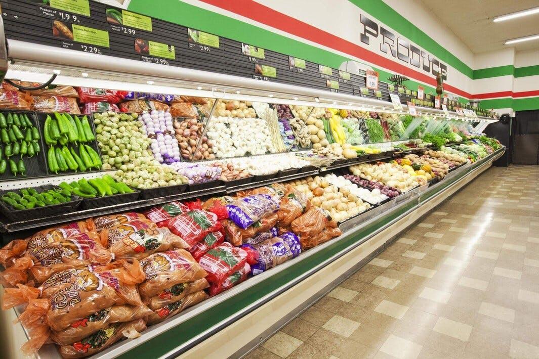 Aisles within a grocery store are filled with fresh produce